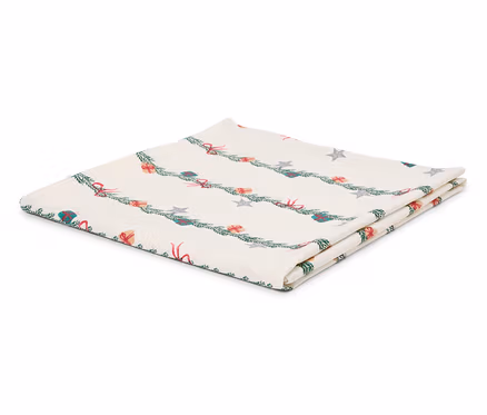 Gefaltete weiße Tischdecke mit weihnachtlichem Motiv aus Zweigen, Geschenken und Sternen.