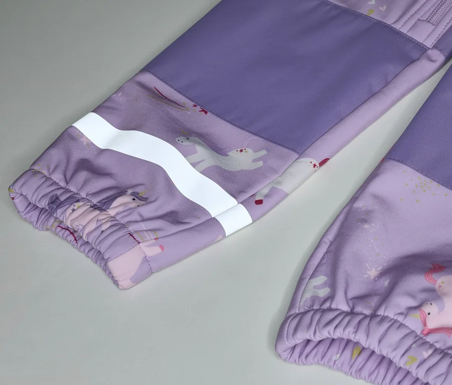 Nahaufnahme von lila Kinderhosen mit Einhornmuster und reflektierendem Streifen am Ärmel.