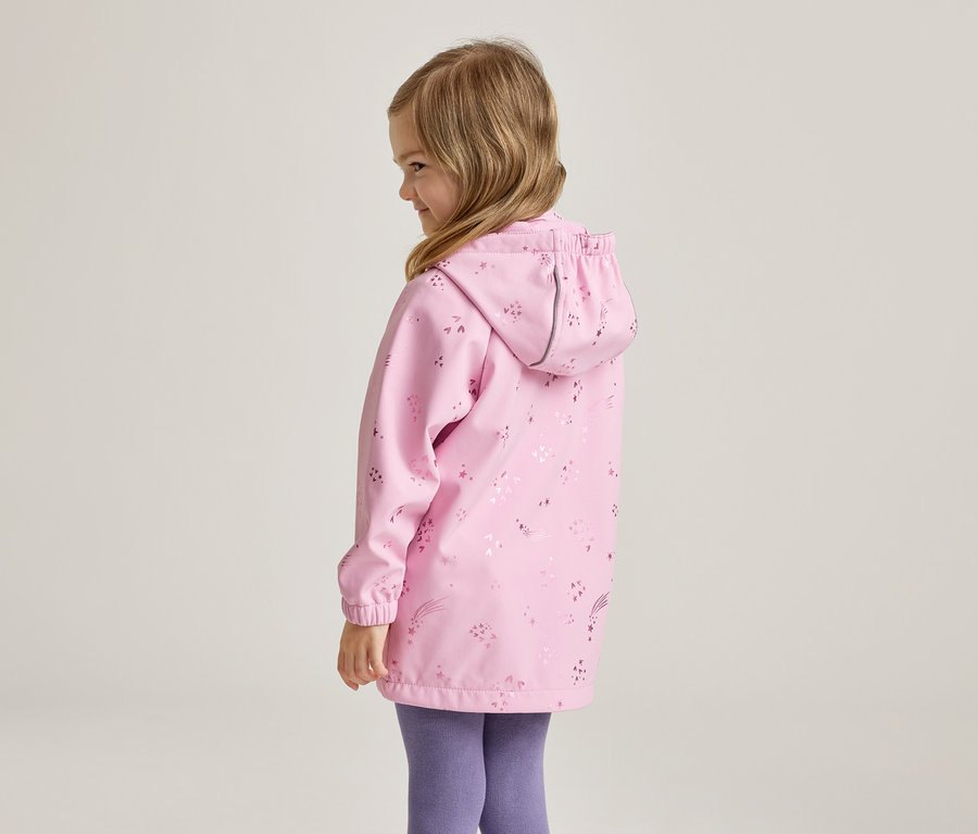 Mädchen von hinten in rosa, gemusterter Regenjacke mit Kapuze und lila Leggings.