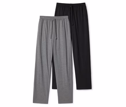 Zwei Jogginghosen, eine graue und eine schwarze, liegen flach. Beide haben einen elastischen Bund mit Kordelzug.