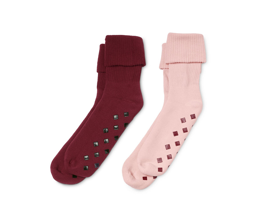 Zwei Paar Stoppersocken: ein Paar bordeauxrot und ein Paar rosa.