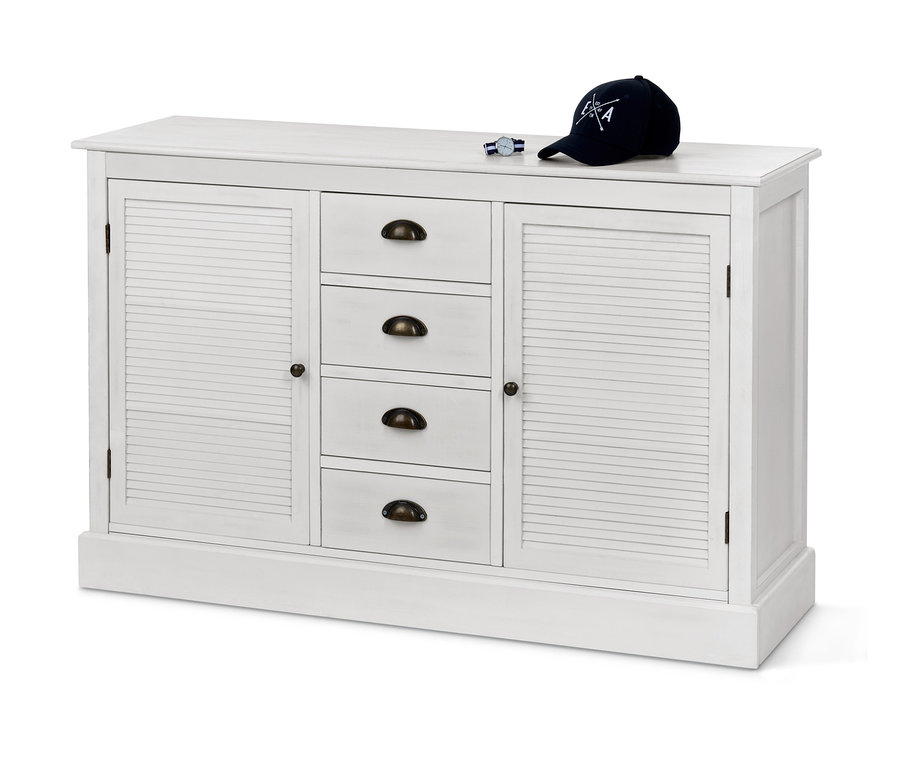 Weißes Sideboard in Lamellenoptik mit vier Schubladen und zwei Schränken. Auf dem Sideboard liegen eine Uhr und eine Baseballkappe.