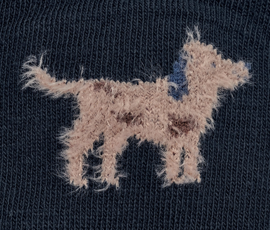 Detailaufnahme einer 3D-Kinder-Socke mit Flausch-Garn, die einen Hund zeigt.
