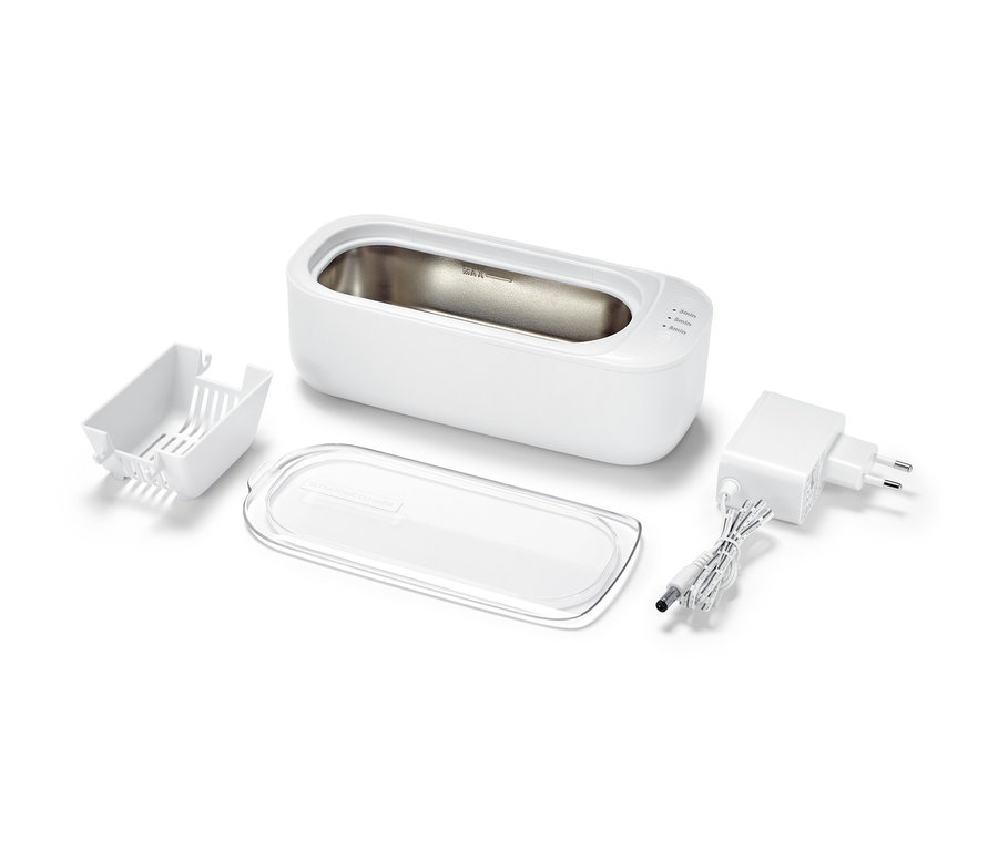 Ein Ultraschallreiniger und Zubehör auf weißem Hintergrund.