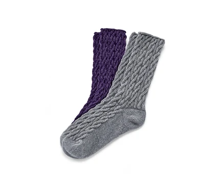 Zwei Paar flauschige Socken mit Zopfmuster, ein Paar in Lila und ein Paar in Grau.