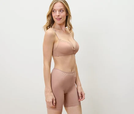 Blonde Frau trägt BH und 2 Radler-Shorts, beige und weiß.