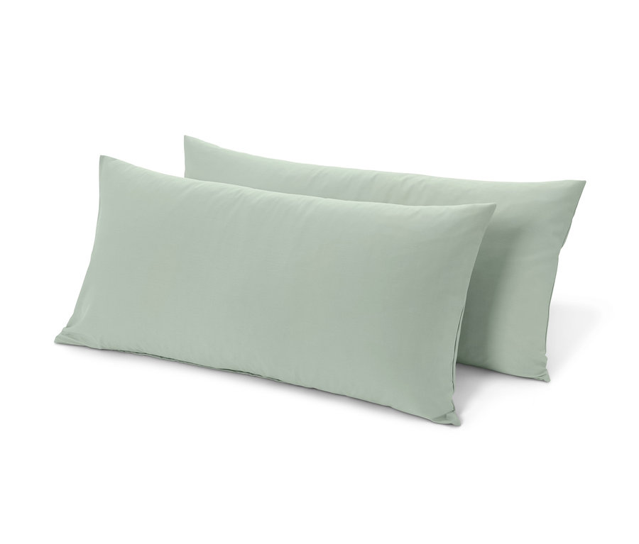 Zwei mintfarbene Renforcé-Kopfkissenbezüge liegen übereinander.