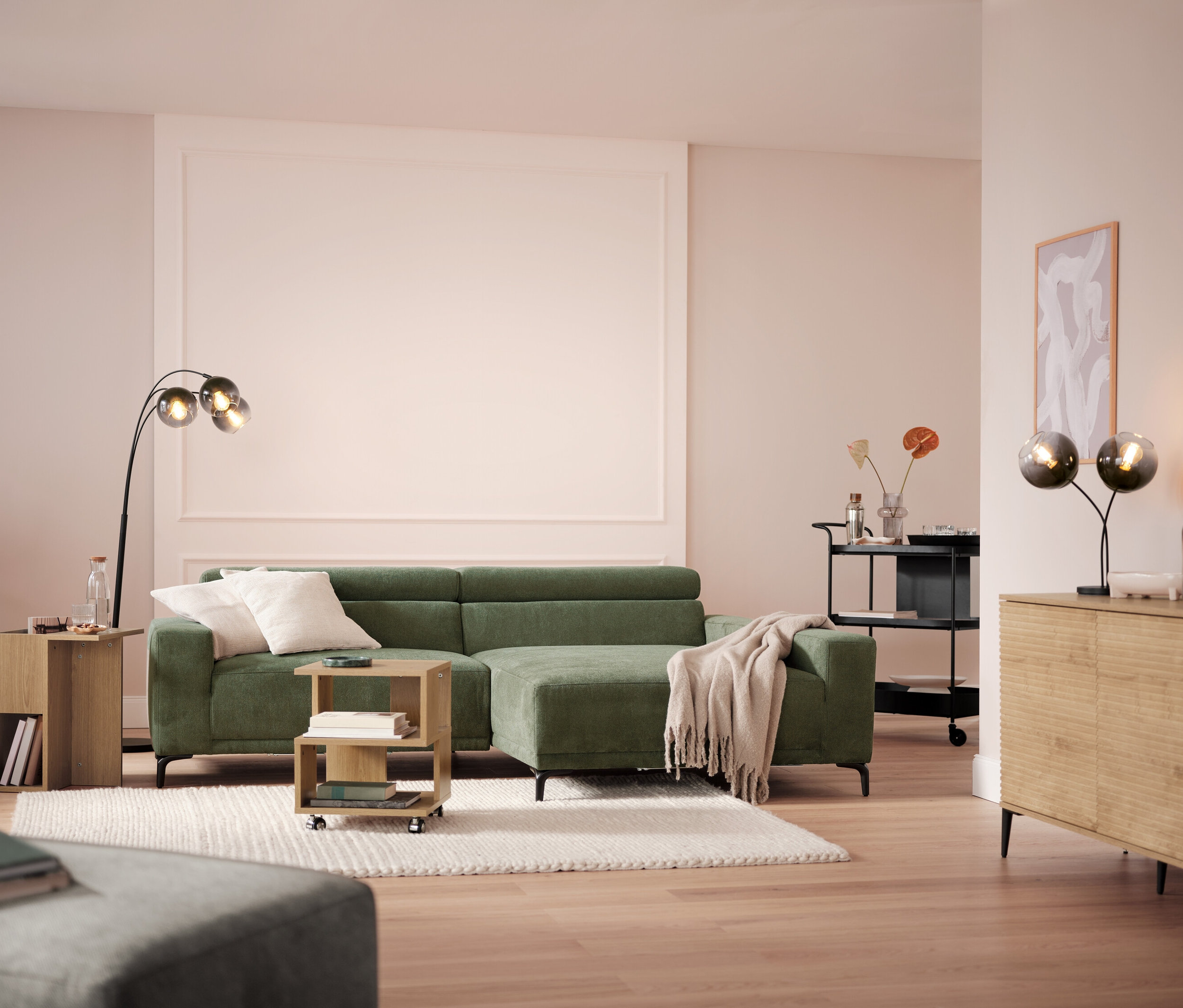 Wohnzimmer mit Sofa, Lampe und Servierwagen mit Tablett.