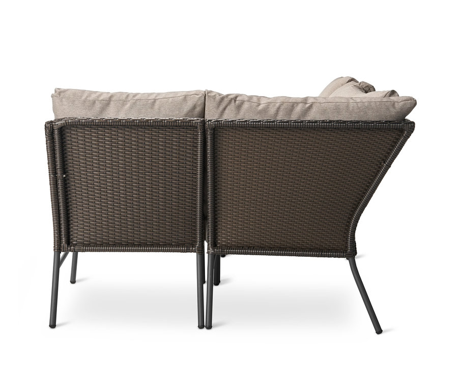 Detail einer Loungeecke mit Polyrattangeflecht und beigen Kissen.