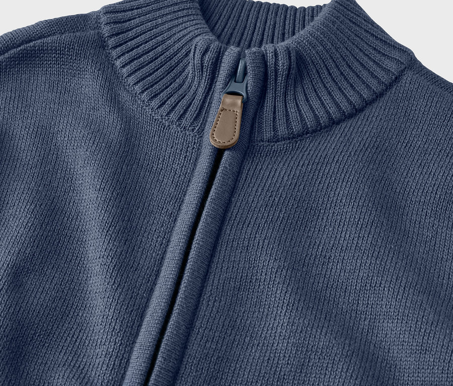 Detailansicht einer Kinder-Strickjacke mit Kragen und Reißverschluss.