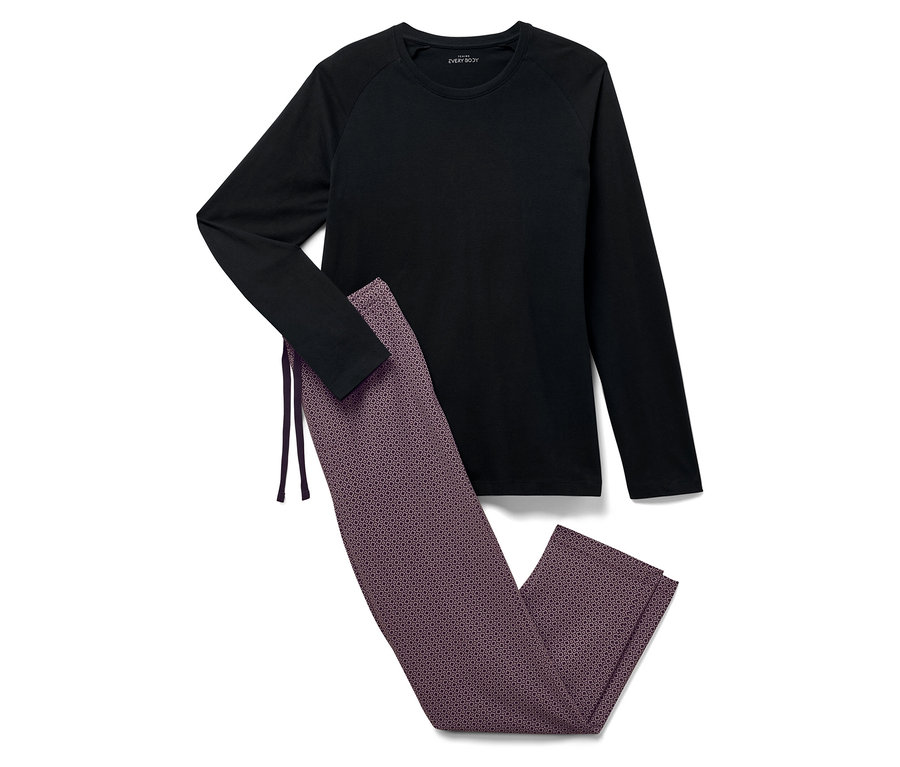 Schwarzes Langarmshirt und gemusterte Hose liegen auf einem weißen Hintergrund.