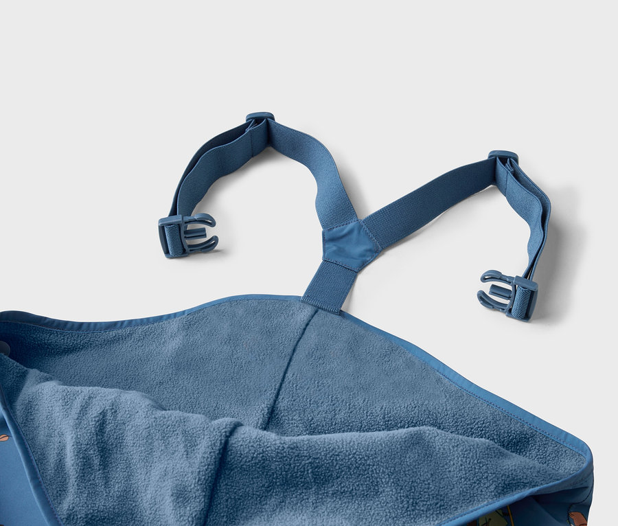 Nahaufnahme eines blauen Badeponchos mit Kapuze und verstellbaren Trägern mit Schnallen.