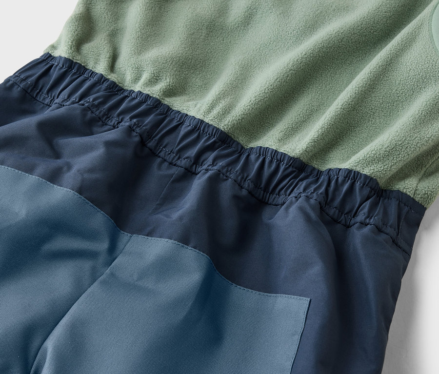 Nahaufnahme eines ärmellosen Overalls in Grün-, Marine- und Blautönen mit elastischer Taille.