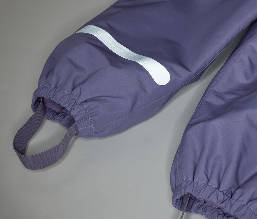 Nahaufnahme der Unterseite einer lila Hose mit elastischem Knöchelbund und reflektierendem Detail.