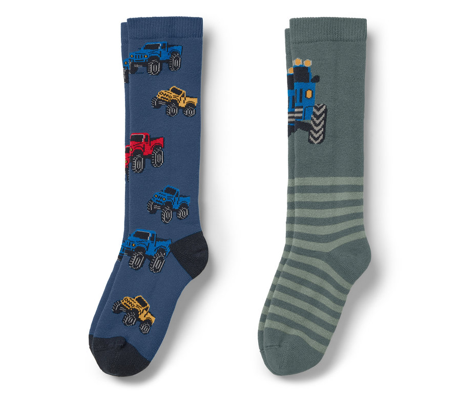 Zwei Socken: eine blaue mit Autos und eine graue mit Streifen und einem Traktor.