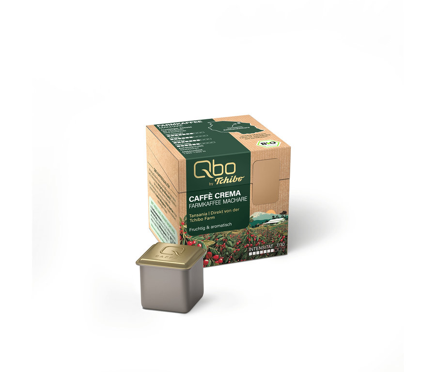 Eine braune Qbo Caffè Crema Farmkaffee Machare Kapselbox mit grünen Akzenten und eine einzelne dunkelgraue Kapsel davor.