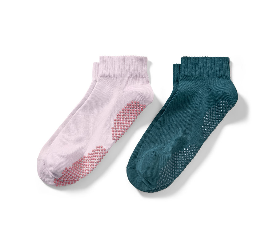 Zwei Paar Yogasocken: ein Paar rosa, ein Paar smaragdgrün.
