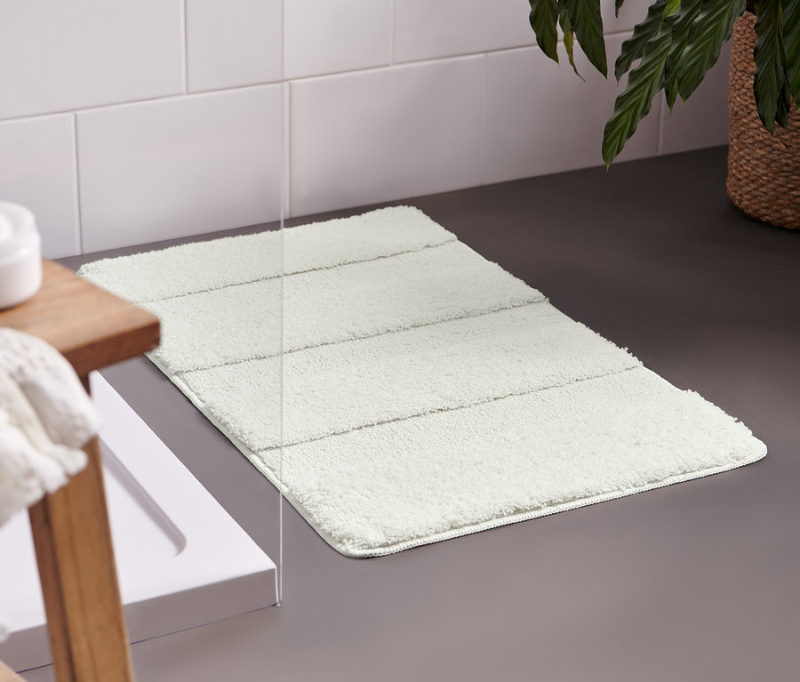 Weiße Wellness-Badematte, ca. 50 x 80 cm, liegt im Badezimmer auf dem Boden.