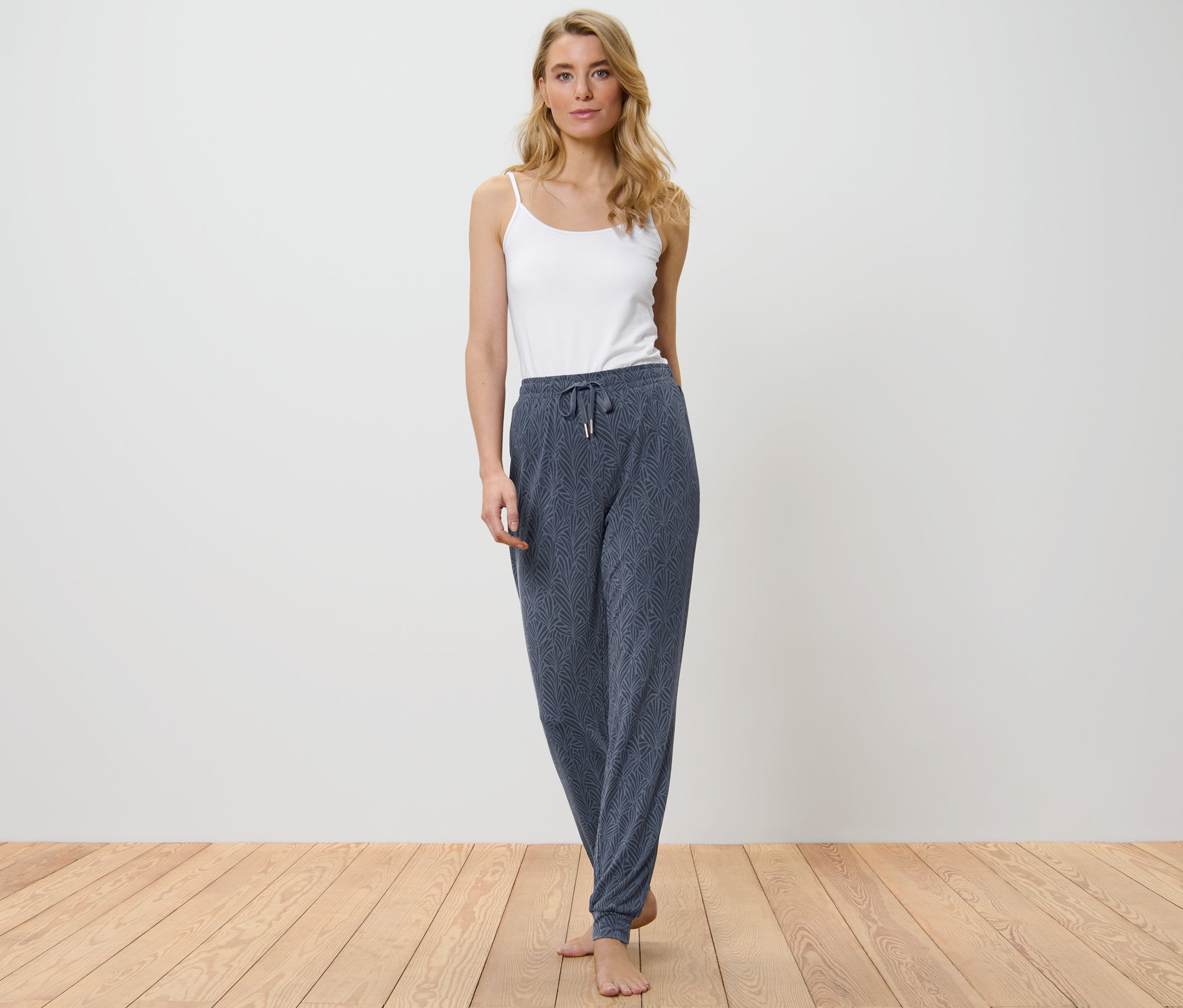 Frau trägt eine Pyjamahose und ein weißes Top.