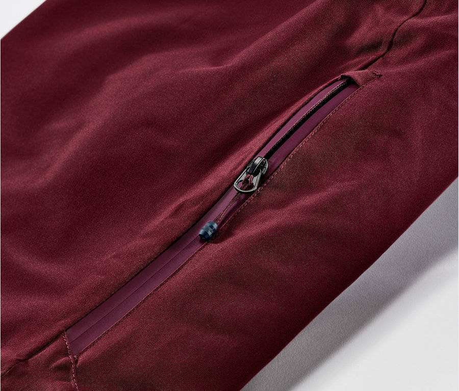 Detail einer weinroten Ski-und-Snowboardhose mit Reißverschluss.
