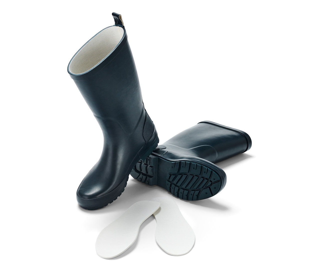 Blaue Kinder-Regenstiefel, einer steht, der andere liegt, daneben Schuheinlagen.