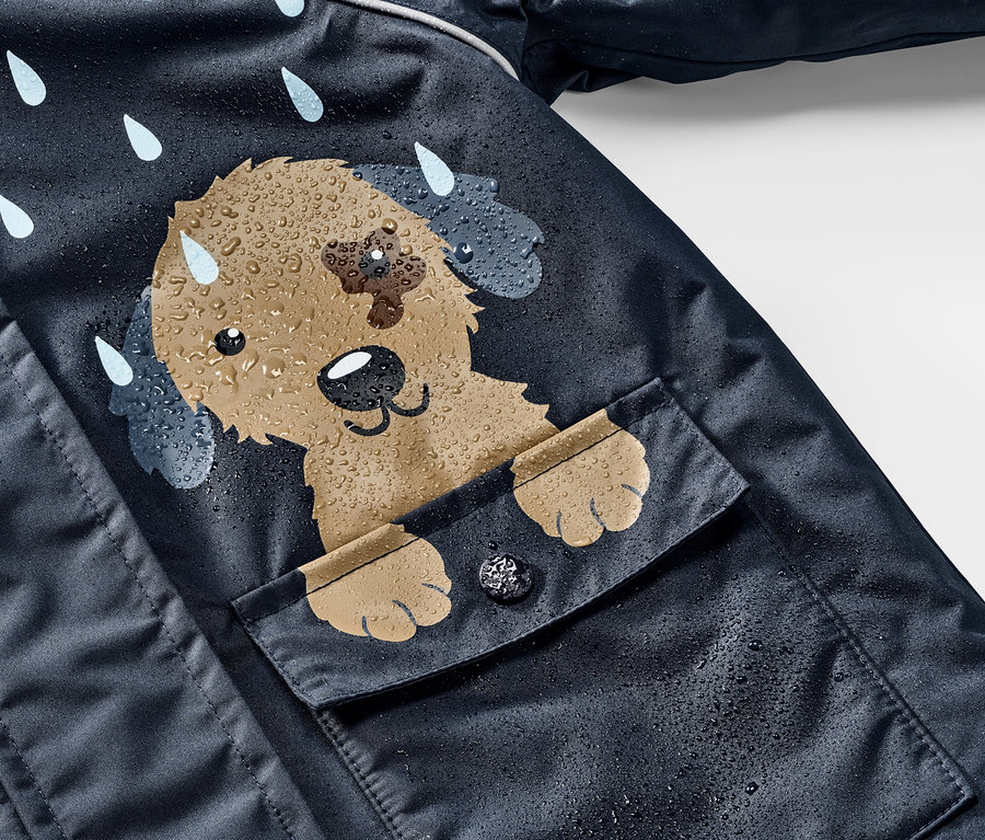 Detail einer Kinder-Thermo-Regenjacke mit Hund-Motiv und Regentropfen.