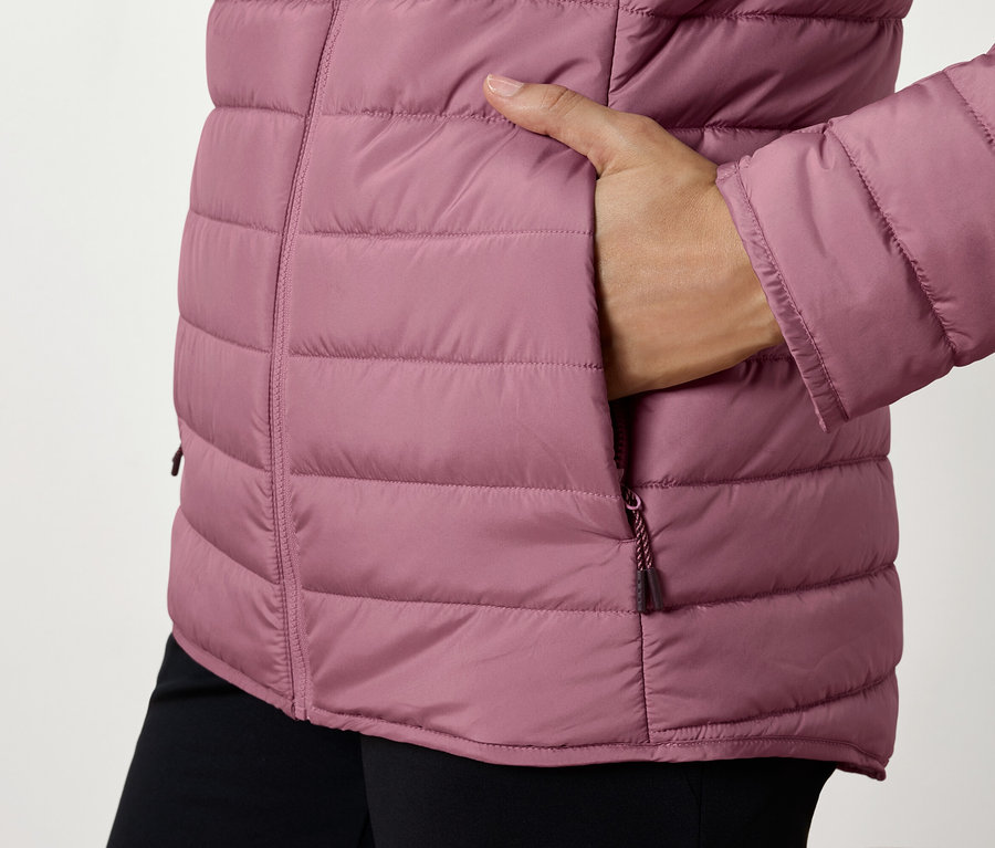 Detailaufnahme einer Damen Steppjacke mit Hand in der Tasche.