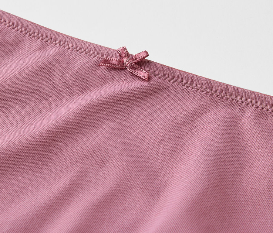 Detailaufnahme von rosafarbenen Slips mit Schleife.