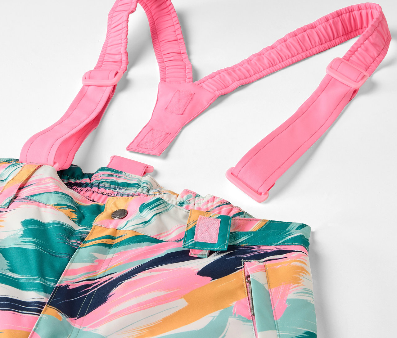 Bunte Latzhose mit abstraktem Muster und pinkfarbenen Trägern.