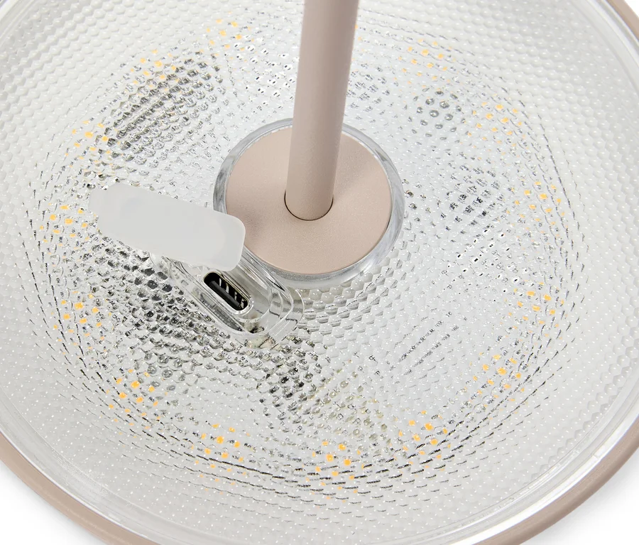 Nahaufnahme des beigen Lampenfußes mit USB-Anschluss und durchsichtigem Lampenschirm.