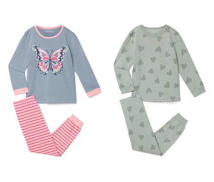 Zwei Sets Kinderpyjamas liegen auf einem weißen Hintergrund. Ein Set ist blau mit einem Schmetterling und rosa Streifen, das andere ist grün mit Herzen.