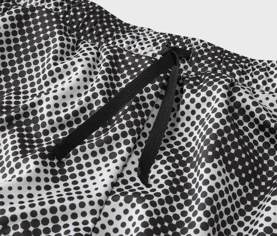 Nahaufnahme der Taille einer weißen Hose mit schwarzem Punktmuster und schwarzem Kordelzug.
