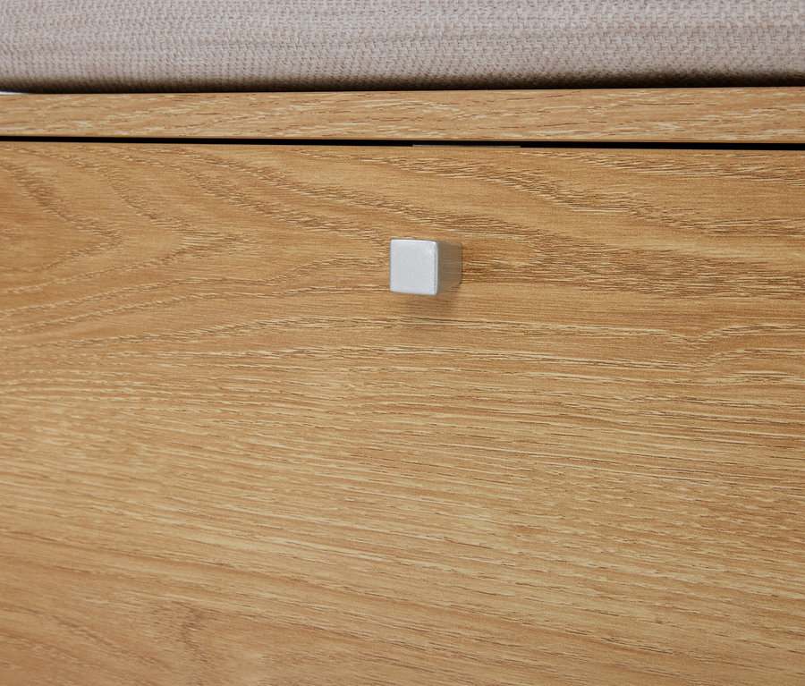 Nahaufnahme einer hellbraunen Holzkommode mit einer Schublade und einem silberfarbenen, quadratischen Griff.