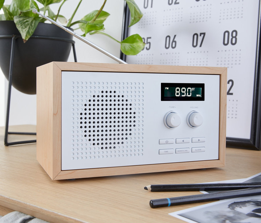 Design-FM-Radio im formschönen Holzgehäuse auf einem Tisch.
