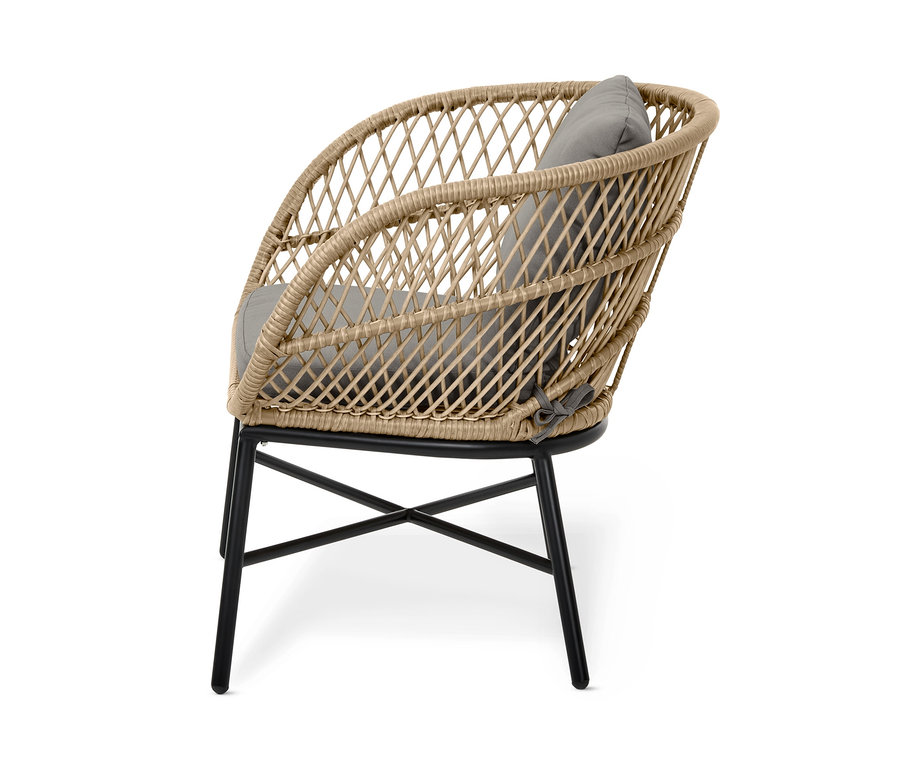 Detailansicht eines beige »Boho« Loungesessels mit Polyrattangeflecht und grauem Kissen auf einem schwarzen Metallgestell.