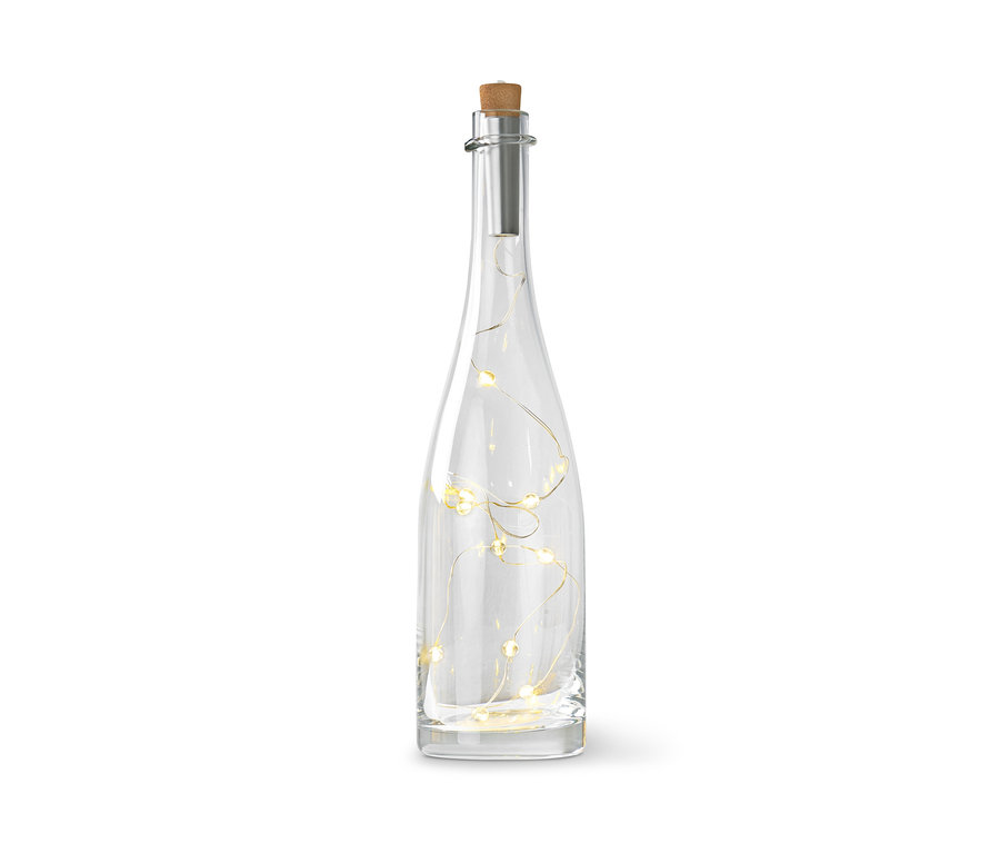 Eine klare Glasflasche mit Korkverschluss und Lichterkette im Inneren.
