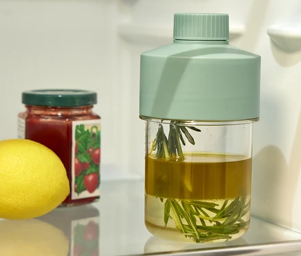 Im Kühlschrank stehen eine Dressingflasche, ein Marmeladenglas und eine Zitrone.