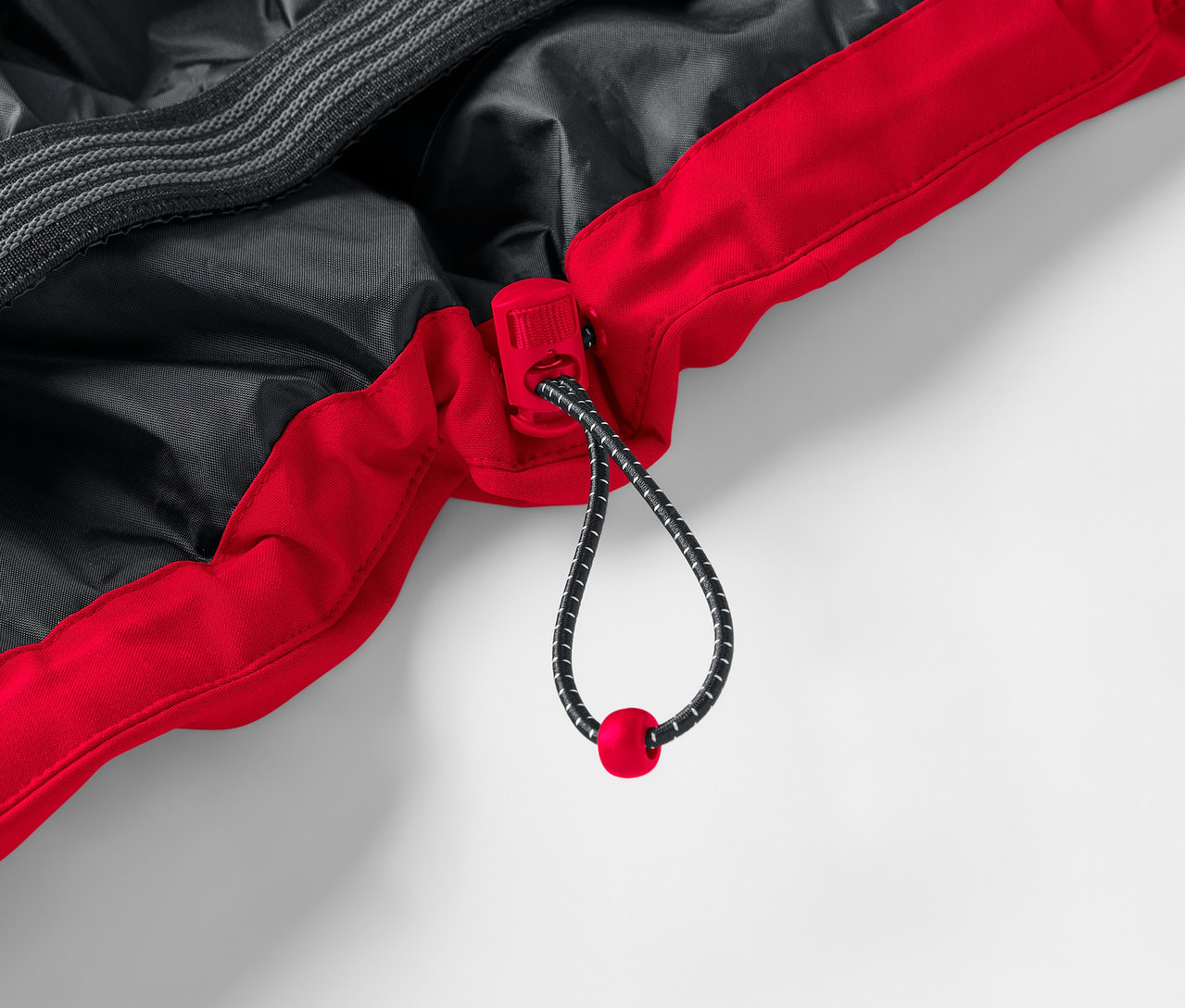 Detail einer rot-schwarzen Jacke mit Kordelzug.