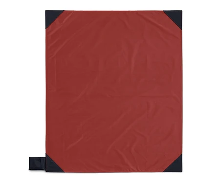 Eine rote Mini-Picknickdecke mit dunkelblauen Ecken.