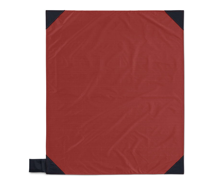 Eine rote Mini-Picknickdecke mit dunkelblauen Ecken.