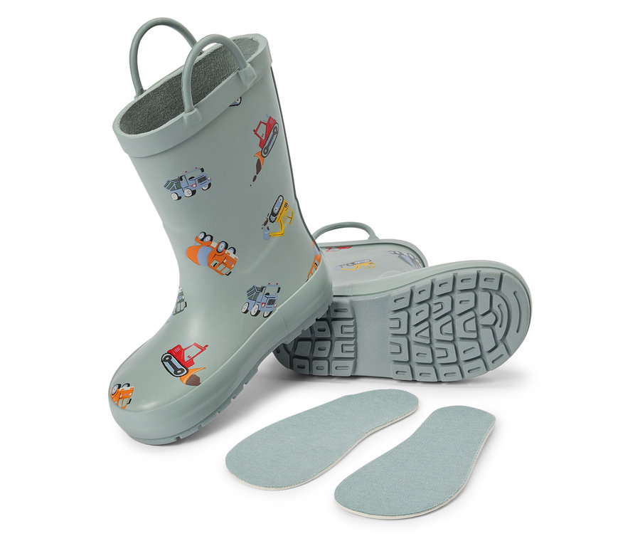 Ein Paar hellblaue Kindergummistiefel mit Bauarbeiter-Motiven und Einlegesohlen liegen auf einem weißen Hintergrund.