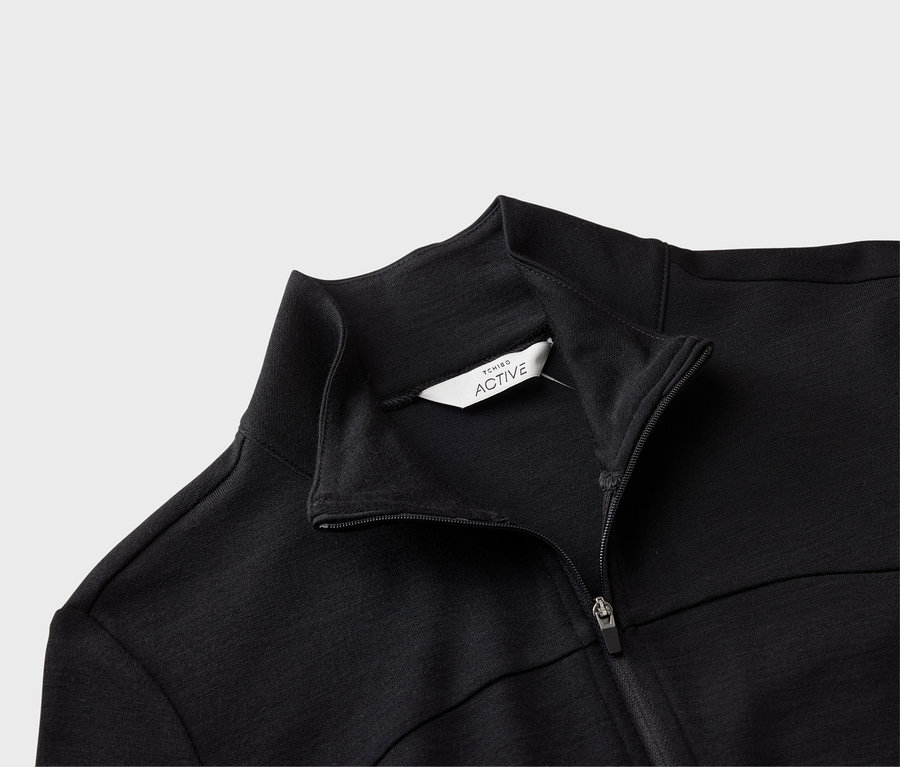 Detailansicht einer schwarzen Tchibo Active Jacke mit Reißverschluss und Kragen.