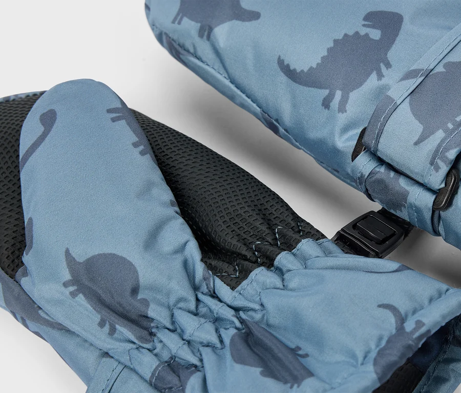 Ein Paar blaue Fäustlinge mit einem dunkelblauen Dinosaurier-Muster, einer schwarzen strukturierten Handfläche, einem elastischen Handgelenk und einer schwarzen Schnalle, die sie verbindet.