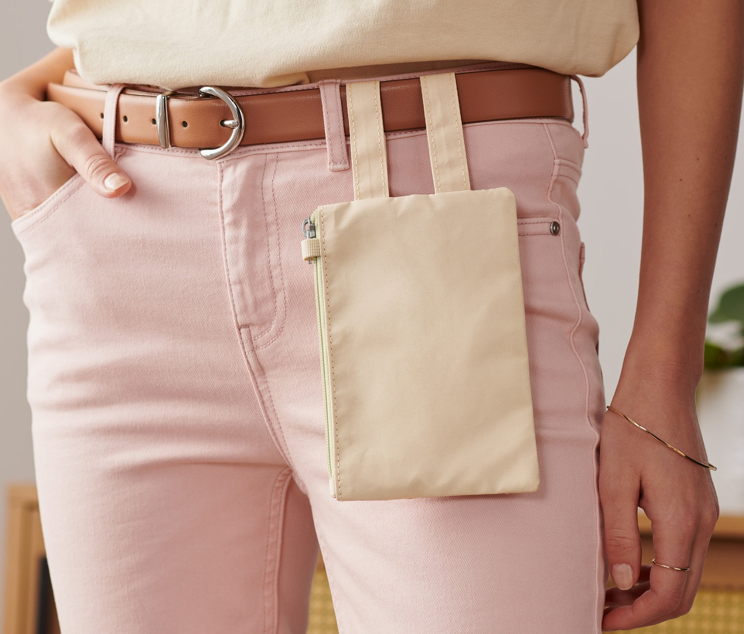 Frau trägt rosa Jeans und eine Gürteltasche.