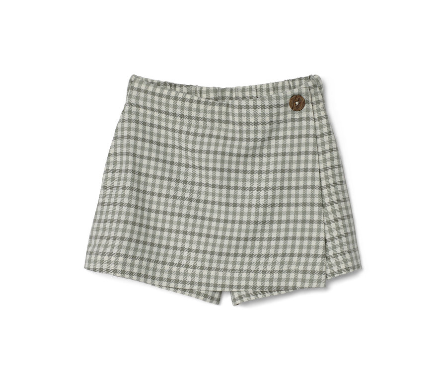 Ein Kinder-Hosenrock mit Karomuster und Holzknopf.