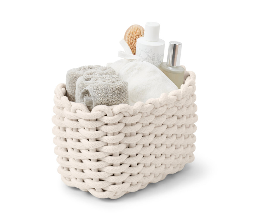 Ein geflochtener Korb gefüllt mit Handtüchern und Flaschen.