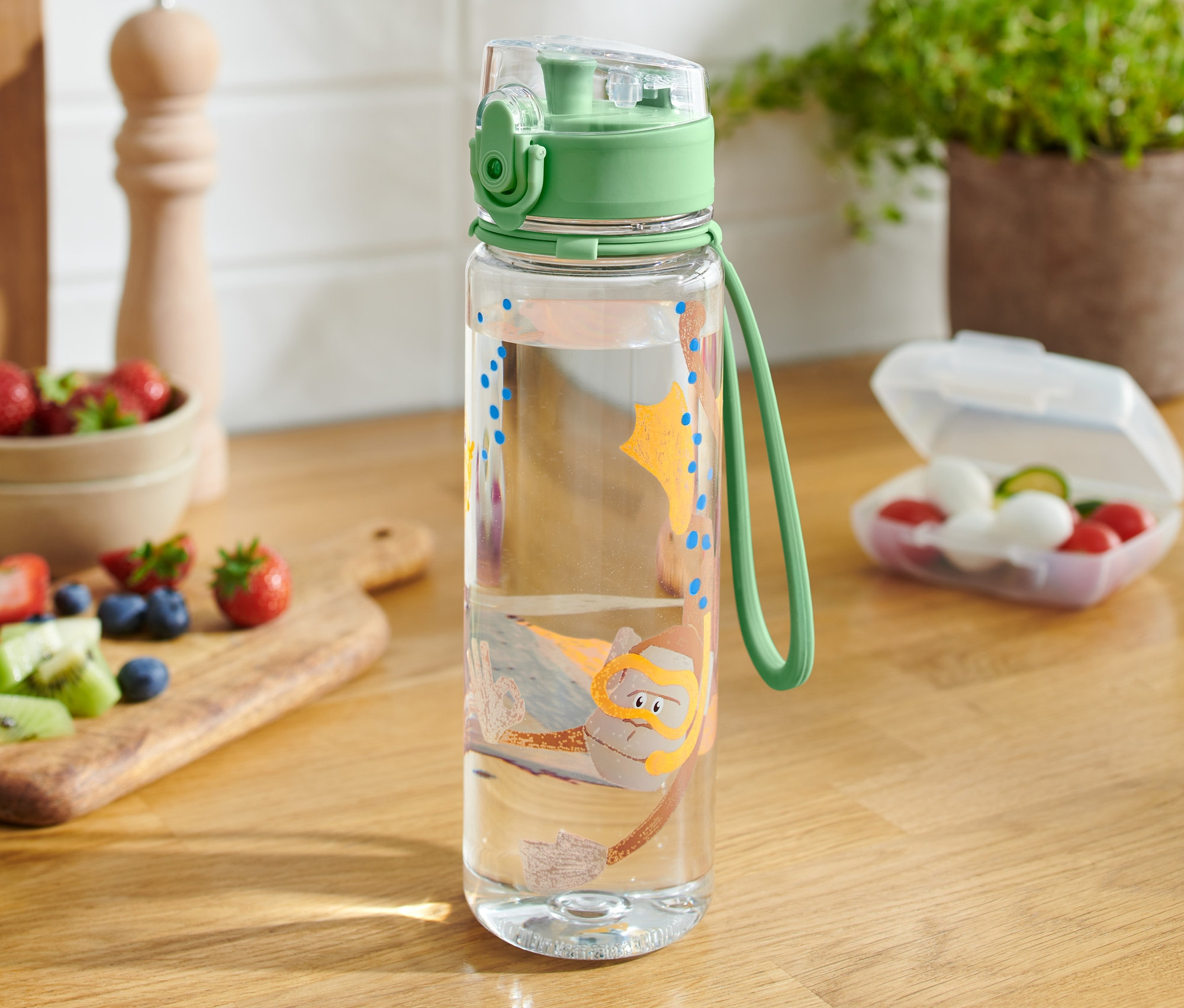 Eine durchsichtige Trinkflasche mit einem Taucher-Motiv steht auf einem Holztisch.