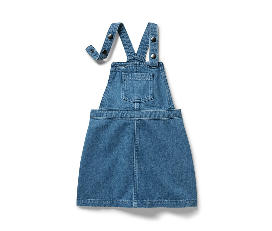 Ein blaues Kinder-Latzkleid aus Jeansstoff ist vor einem weißen Hintergrund zu sehen.