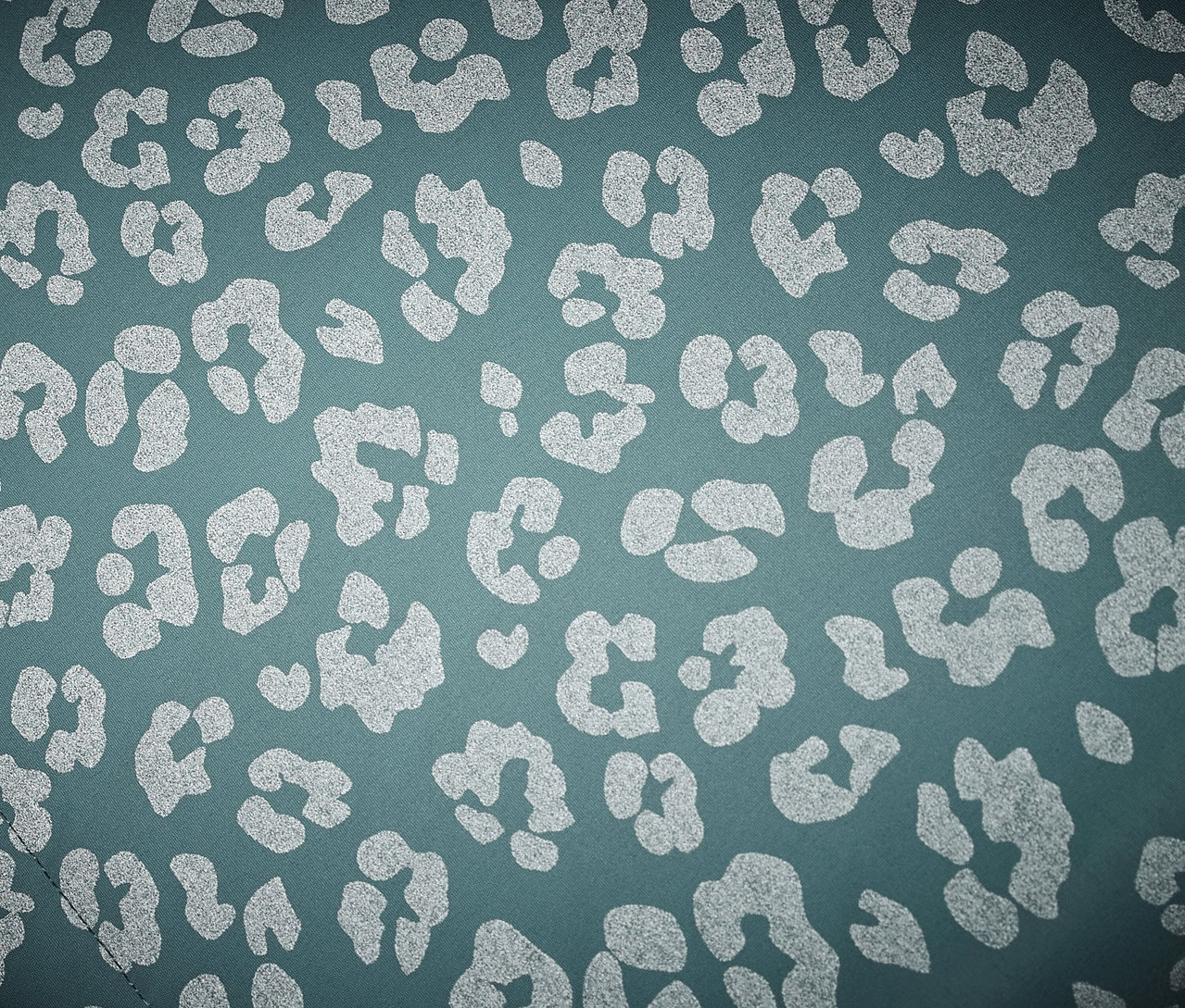 Nahaufnahme einer Kinder-Thermo-Regenjacke mit reflektierenden Elementen im Leopardenmuster.