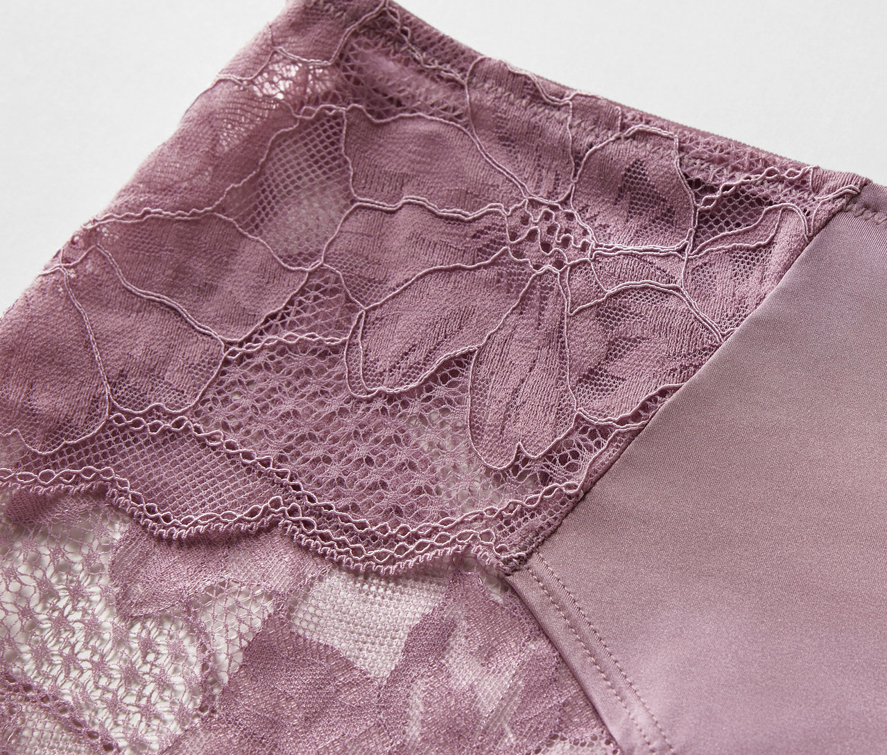 Detailaufnahme von 3 Pantys in Lila mit Blumenspitze.